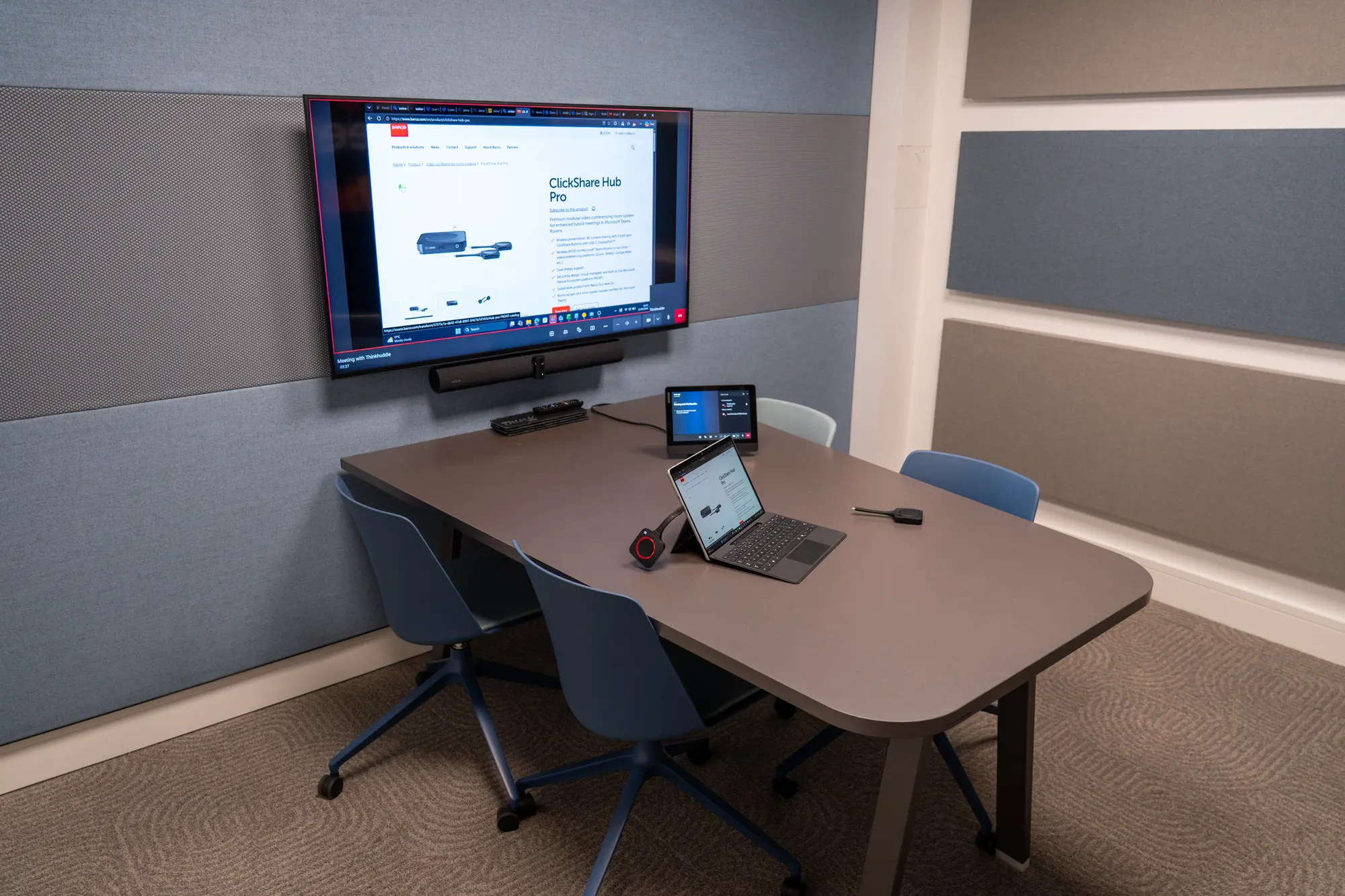 A meeting room fitted with Barco ClickShare, a wall-mounted screen and a touch panel